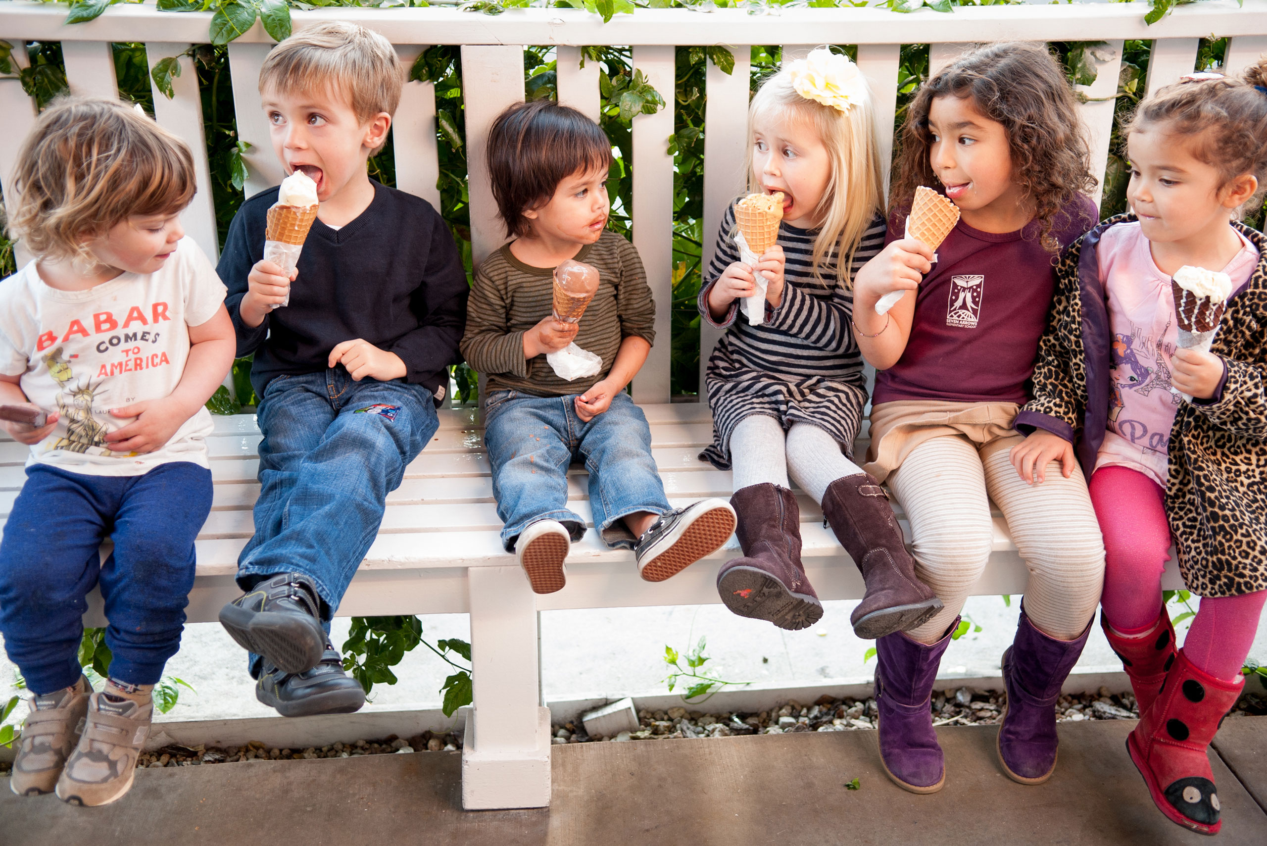 Kids sitting on a white bench eating ice cream at the Brentwood Country Mart shop