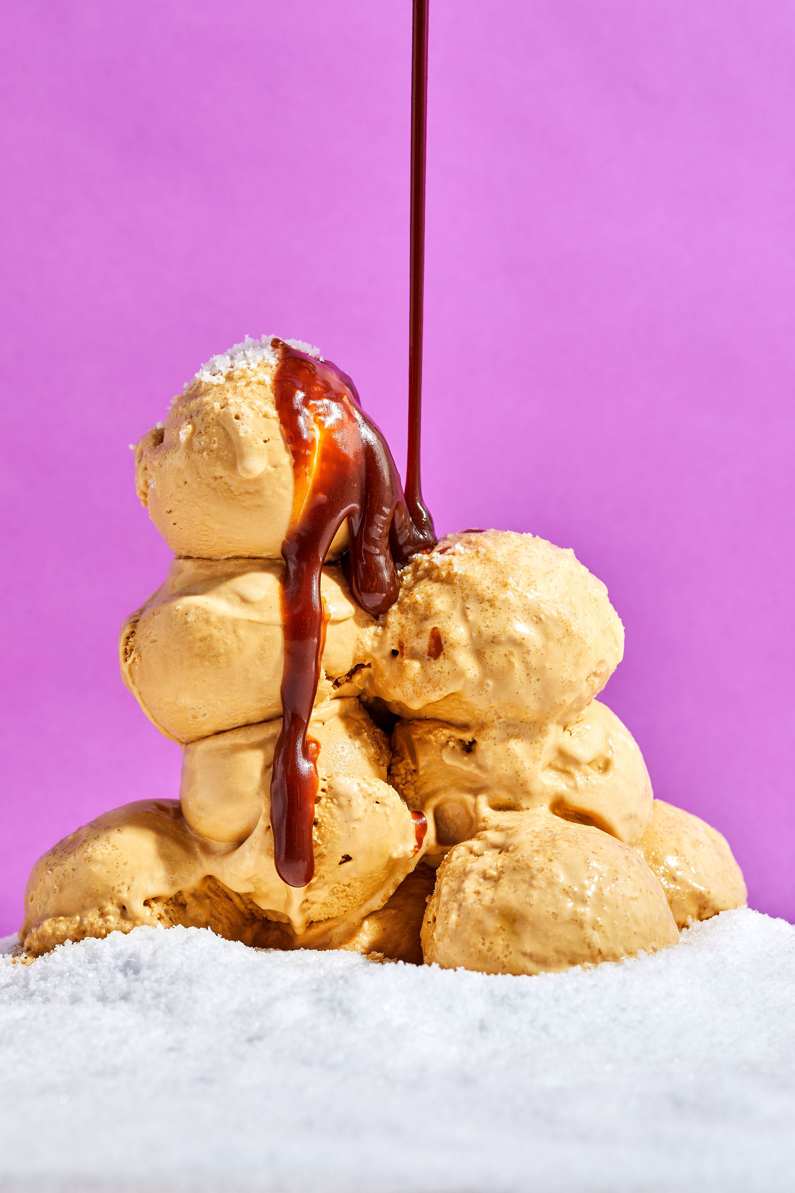 Salted Caramel Ice Cream caramel sauce pouring over scoops of salted caramel ice cream